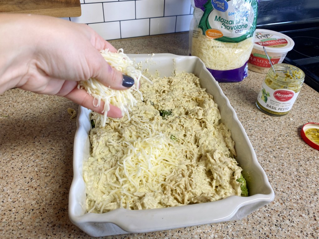 topping keto chicken broccoli pesto casserole with shredded cheese