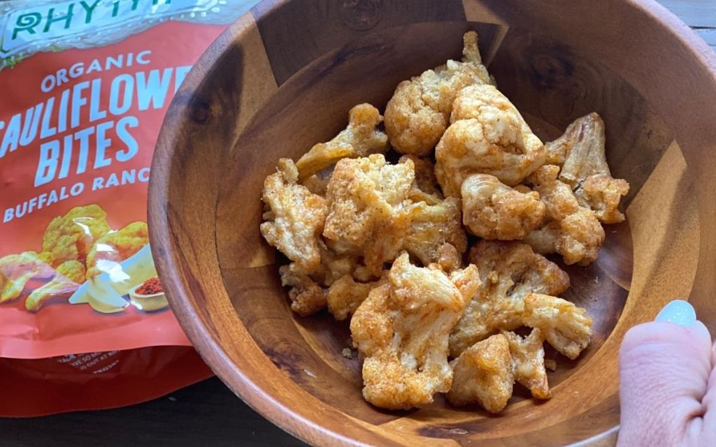 A hand holding a bowl of dried cauliflower