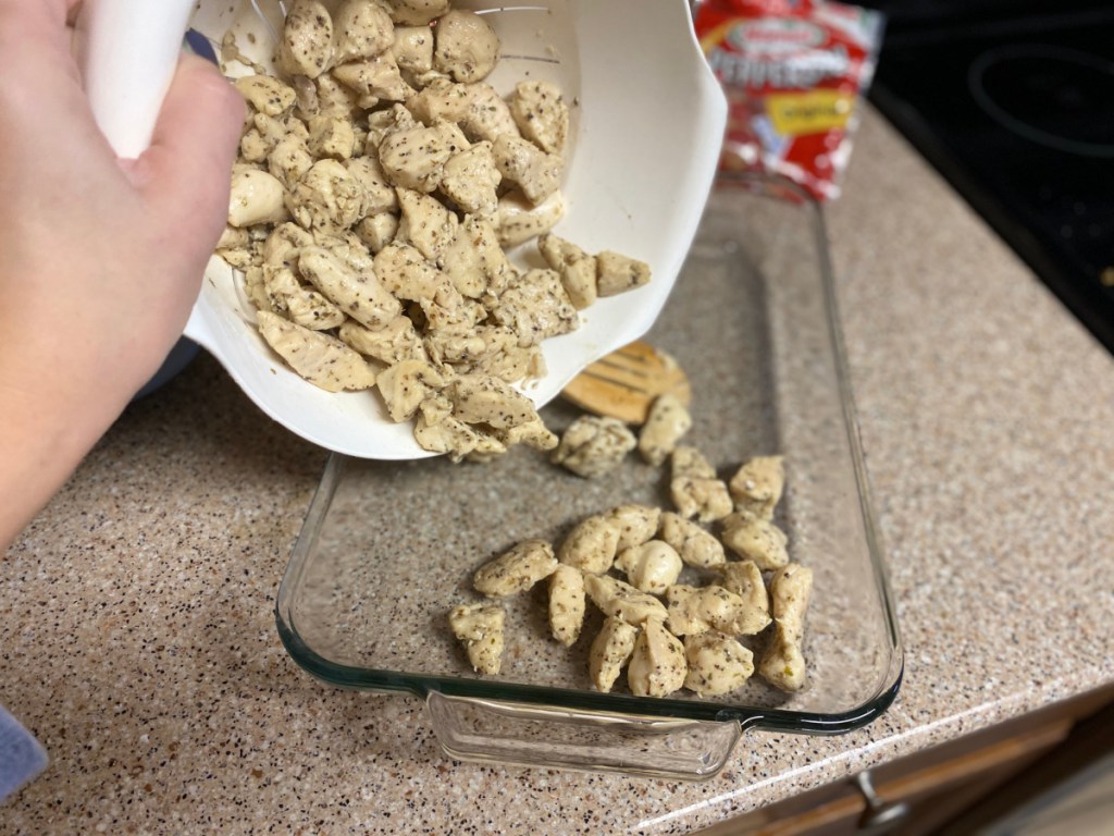 pouring cooked chicken into a casserole dish