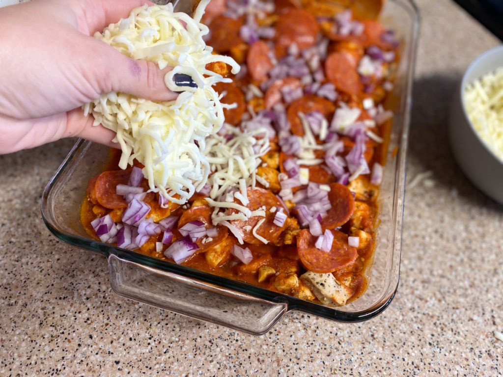 topping casserole with shredded cheese