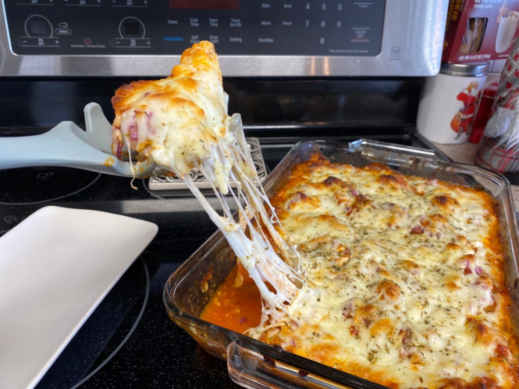 scooping out keto chicken pepperoni casseroli and plating