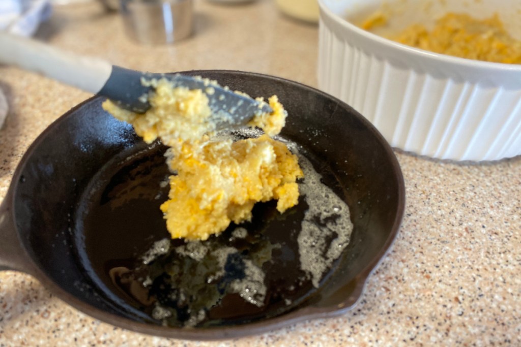 adding batter to a cast iron skillet