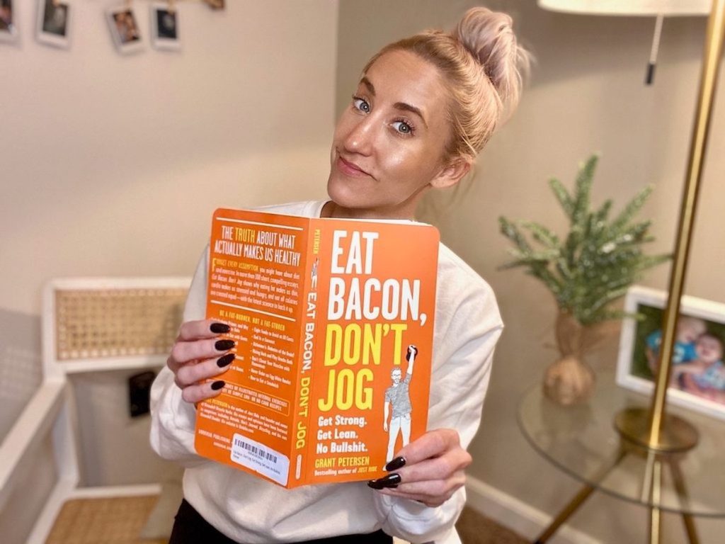woman holding eat bacon don't jog book