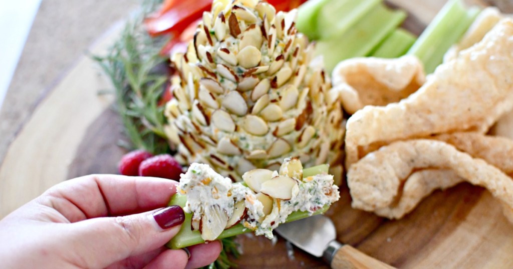 eating a bite of keto pine cone cheese ball