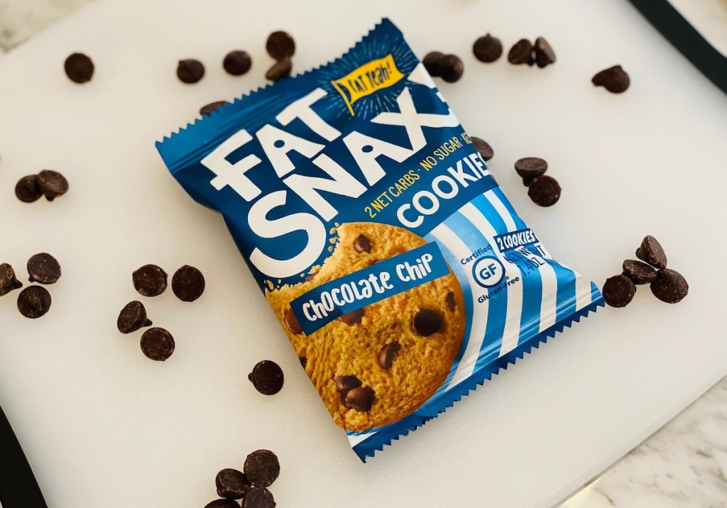 fat snax chocolate chip cookie on counter with chocolate chips