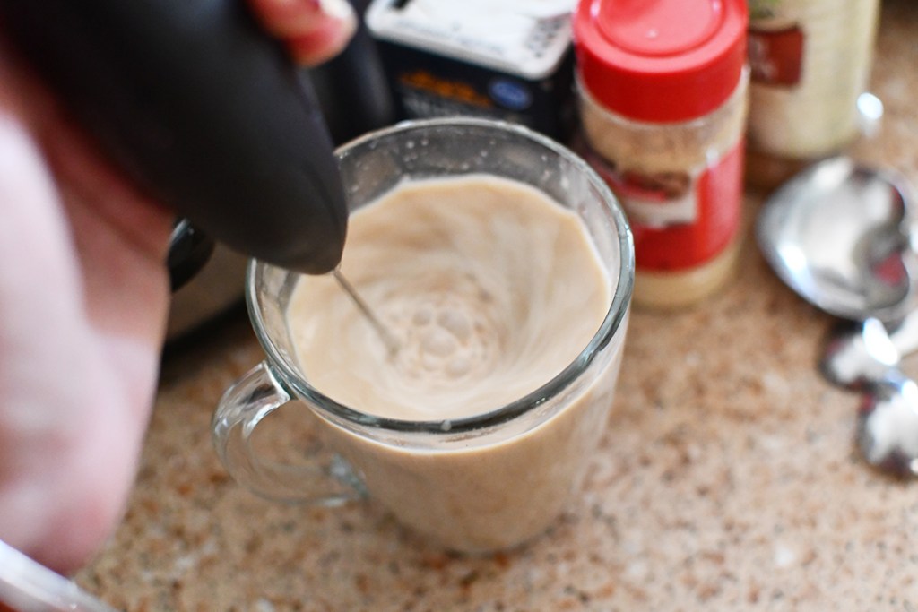 using hand frother to whip keto gingerbread latte