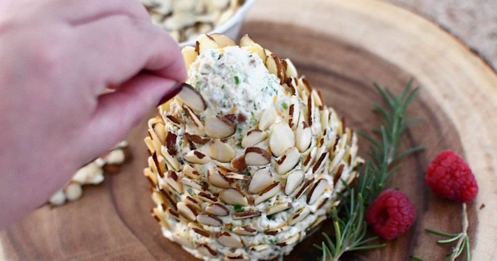 inserting almonds into pinecone cheese ball 