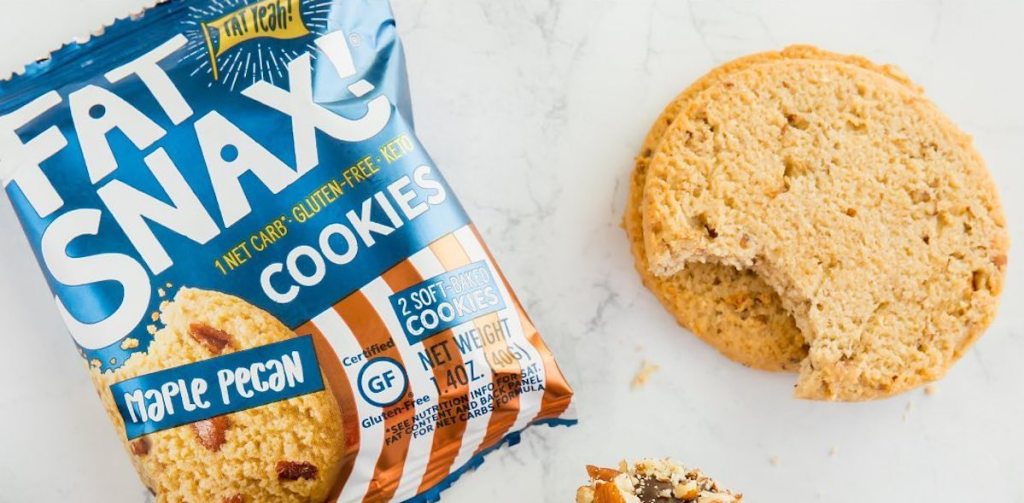 fat snax maple pecan cookie bag sitting next to two cookies on counter