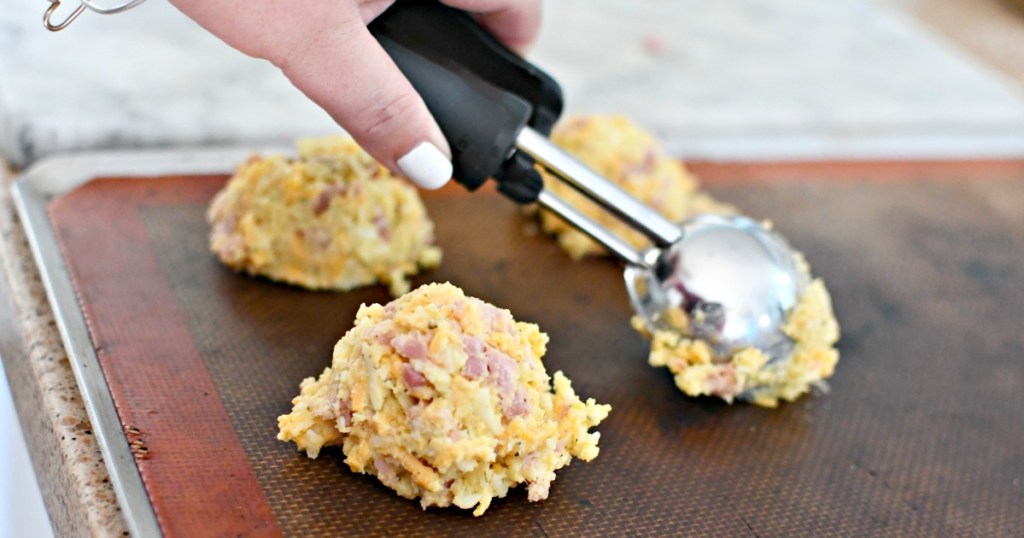 scooping keto ham rolls onto baking tray
