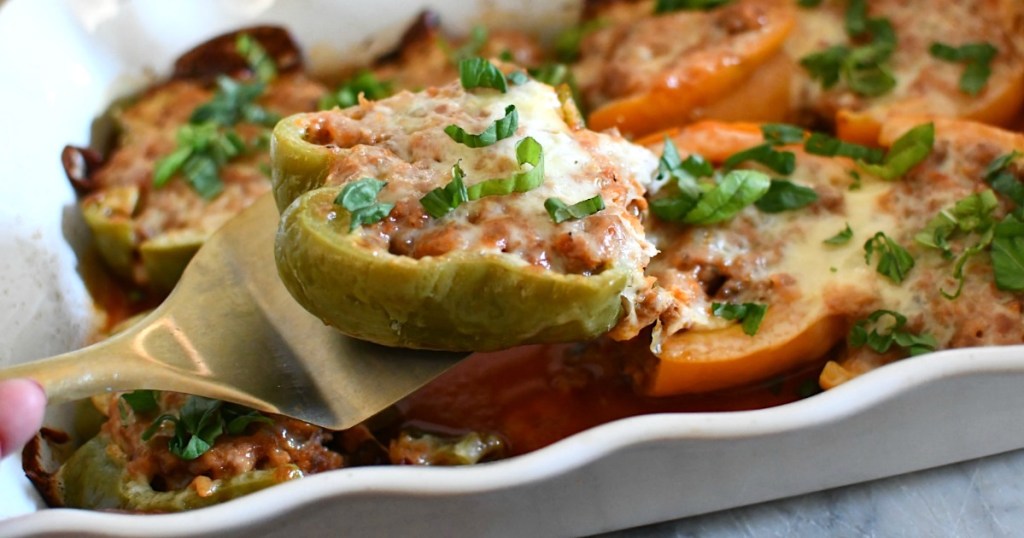 taking keto stuffed bell pepper out of casserole dish 