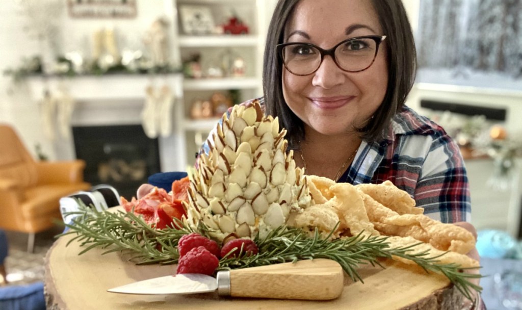 woman holding a pine cone cheese ball