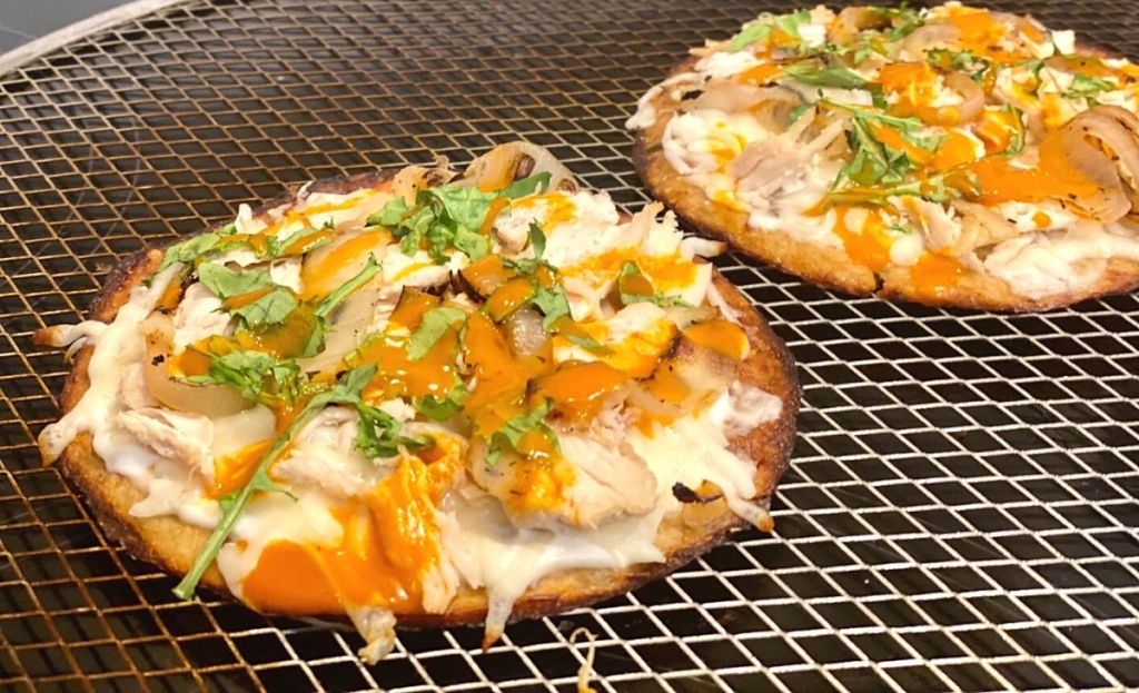 Two flatbreads on a pizza pan