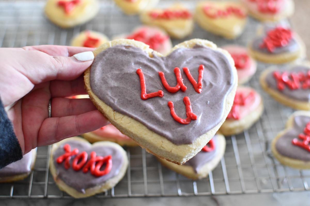 Hand holding up Conversation Heart Cookies for Valentines Day 2024