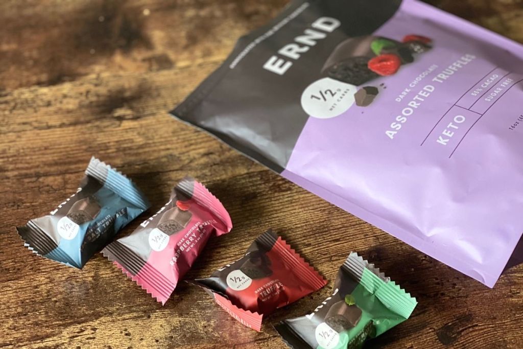 A bag of chocolates next to individually wrapped chocolates on a table