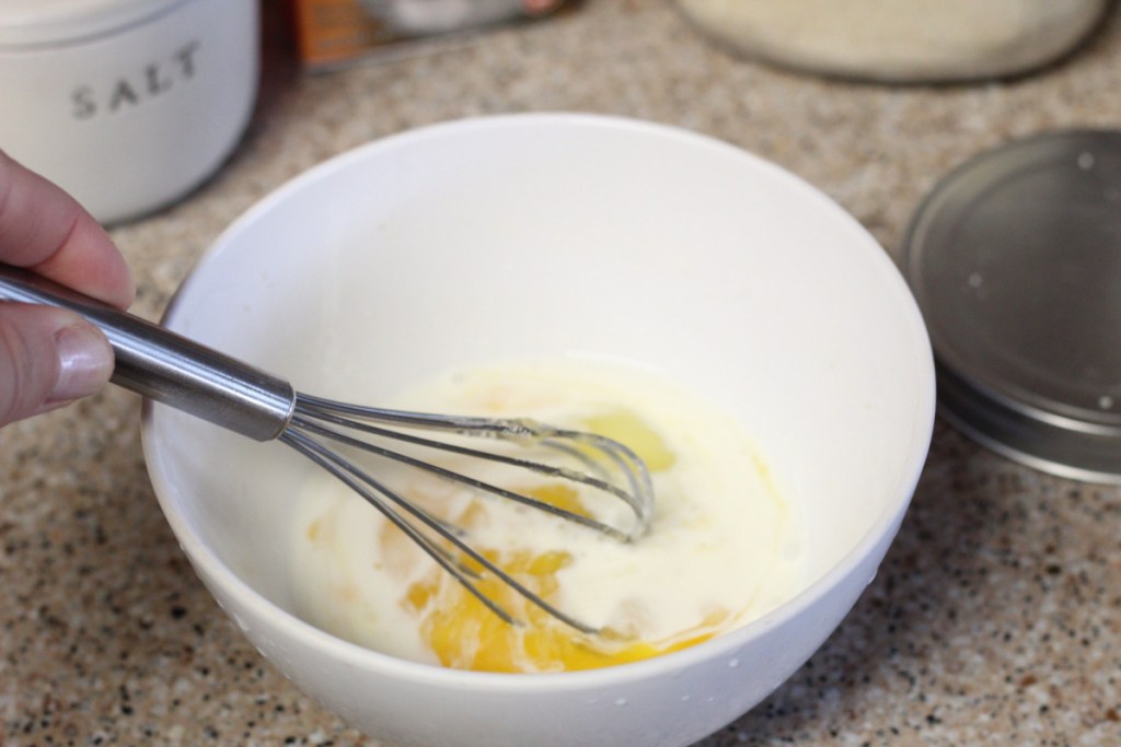 whisking egg and heavy cream in a bowl
