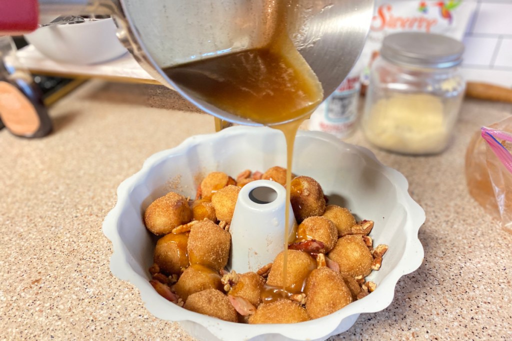 pouring sauce over keto monkey bread