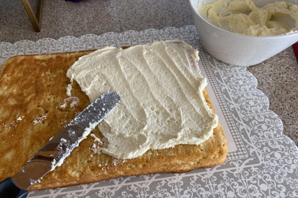 spreading out buttercream frosting on keto cake