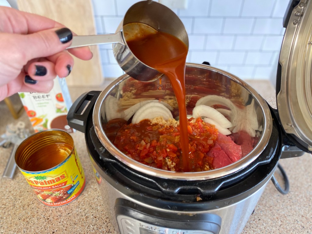 Pouring enchilada sauce in an Instant Pot