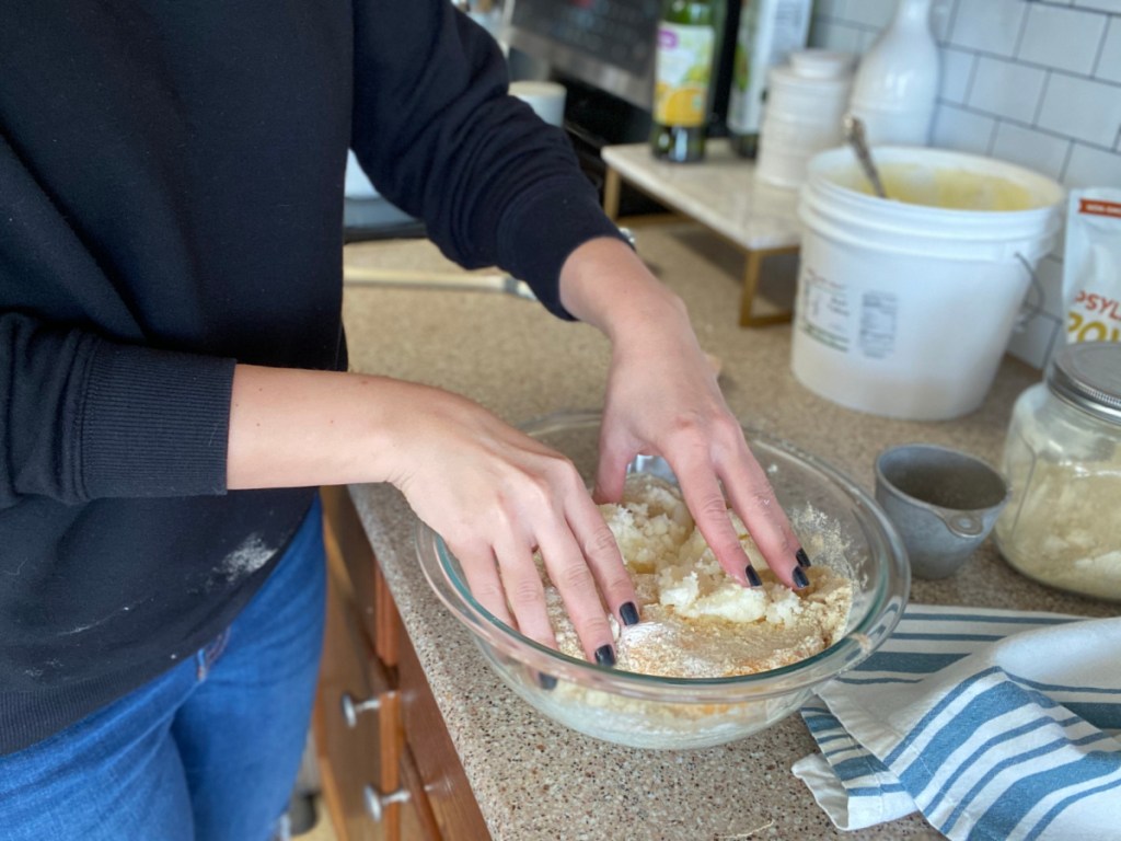 girl kneading masa in a bowl