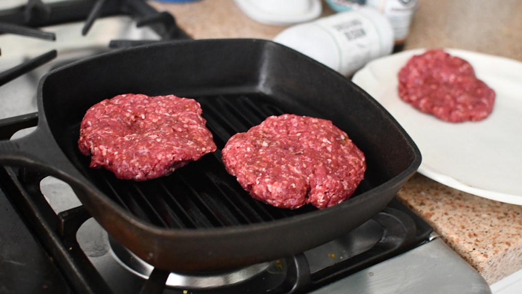 bison burger patties in cast iron grill pan