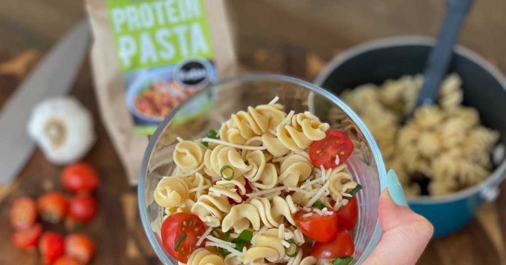 holding bowl of keto protein pasta with tomatoes 