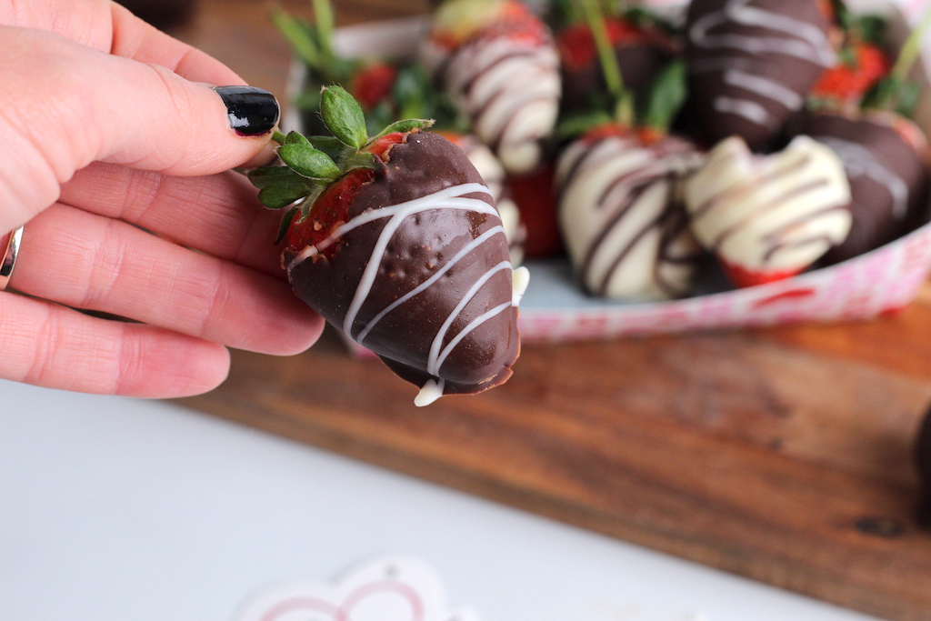holding keto chocolate-covered strawberry