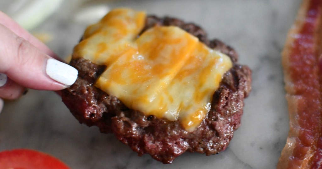 lifting bison burger with cheese 