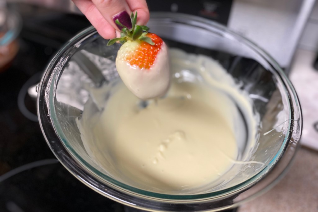 dipping strawberries into melted chocolate