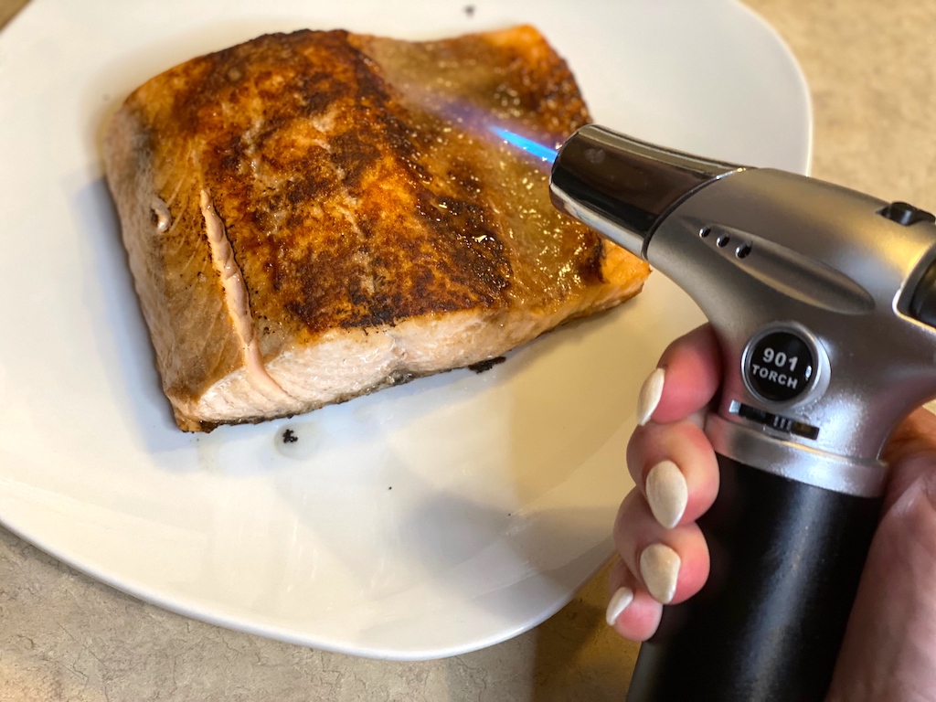 using blow torch to crisp up salmon 