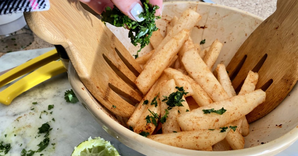 tossing cilantro with jicama sticks