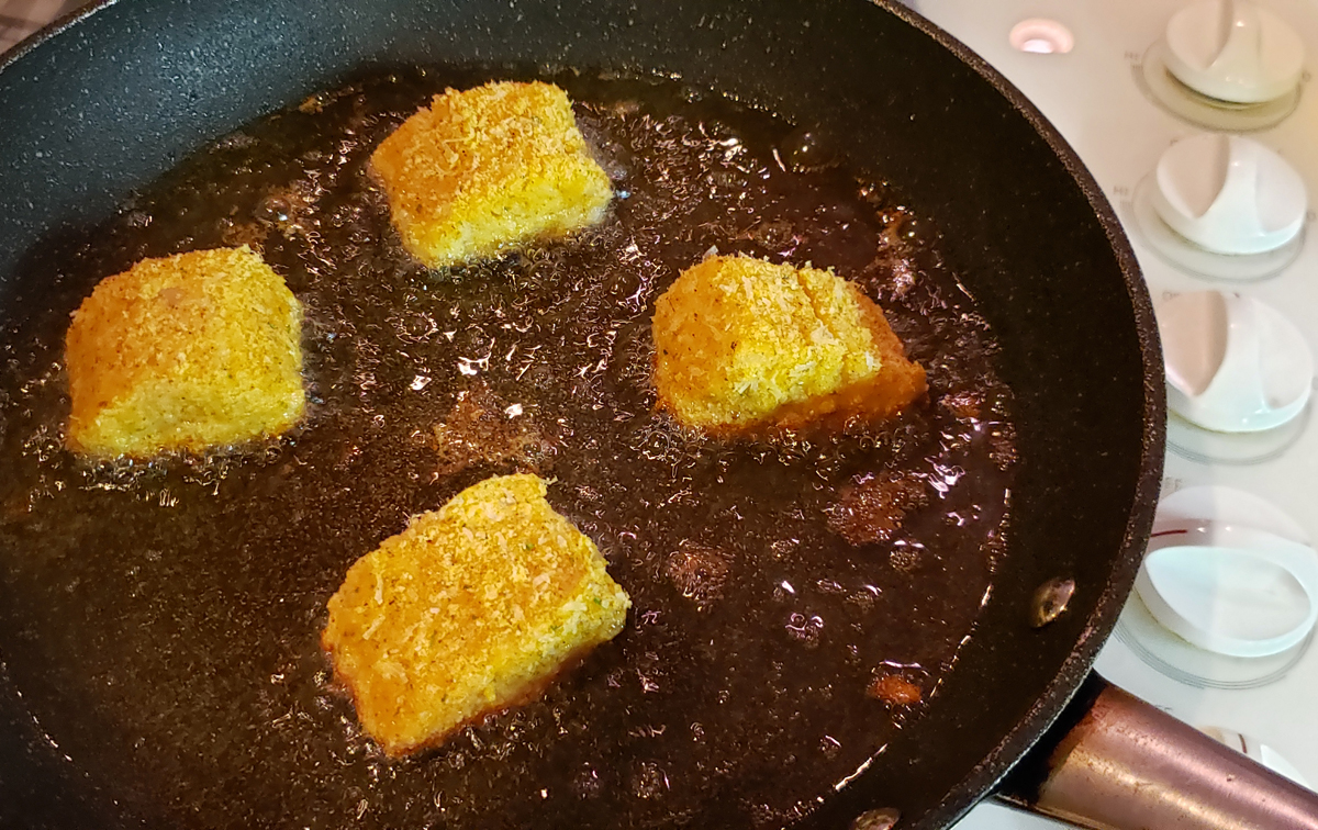 Fish sizzling in frying pan