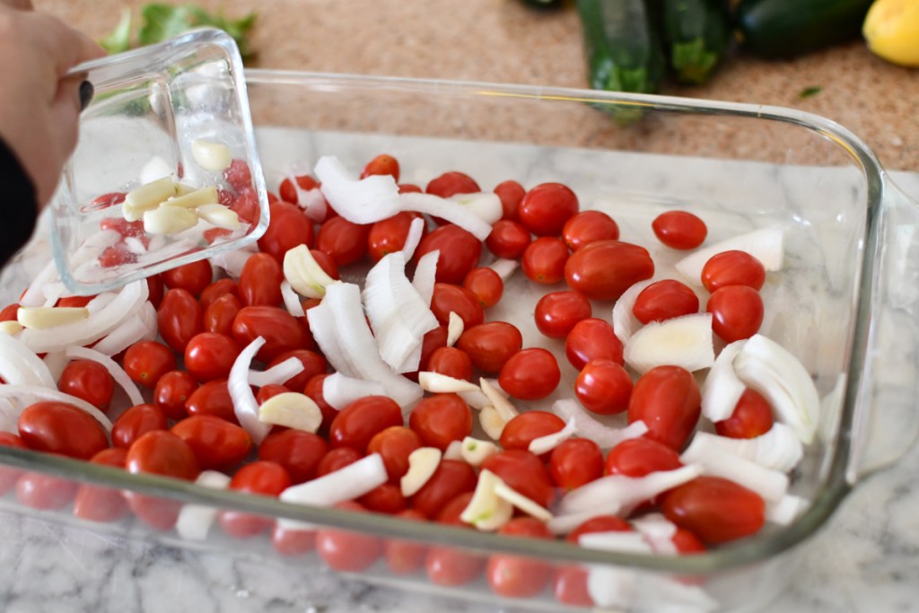 adding fresh garlic to baked feta pasta