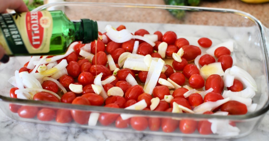 adding olive oil to tomatoes and feta