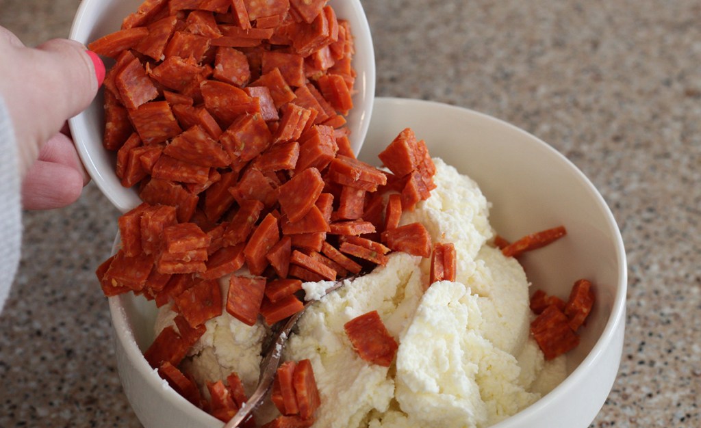 adding pepperoni slices to ricotta cheese