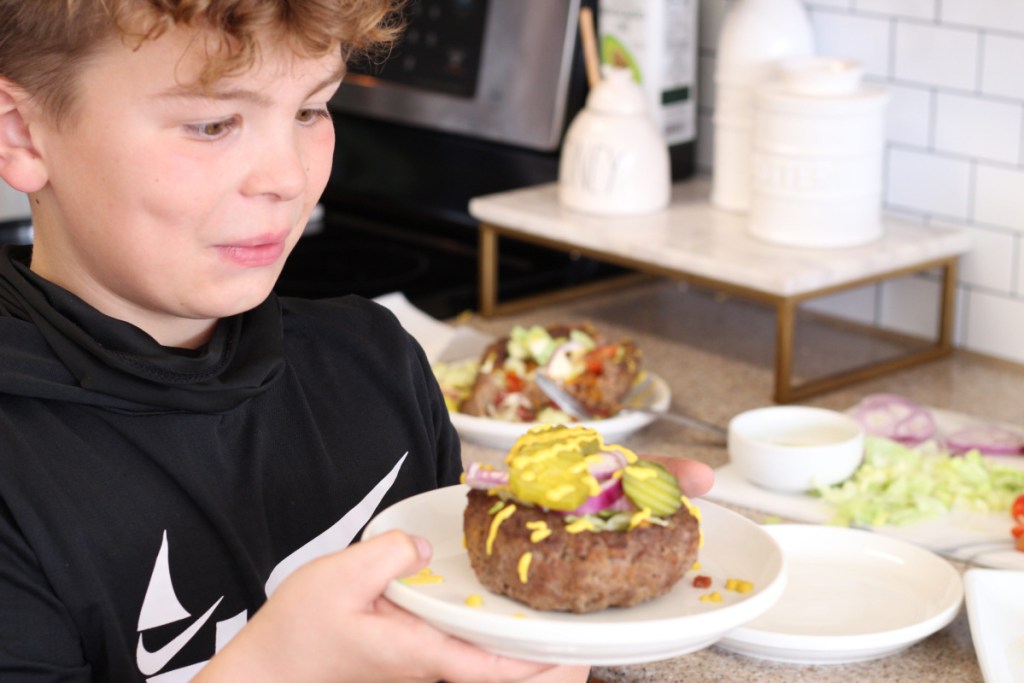 boy holding hamburger bowl