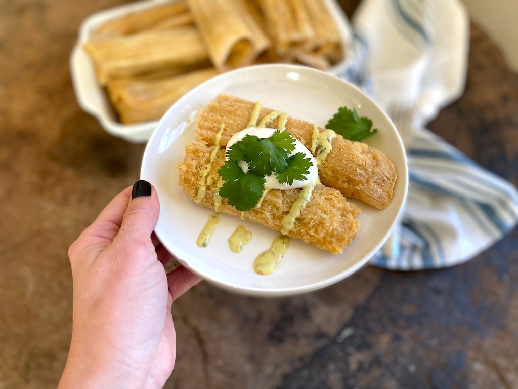 holding keto tamales on plate 