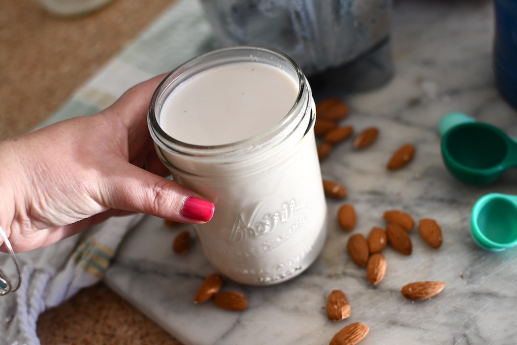 holding jar of homemade almond milk