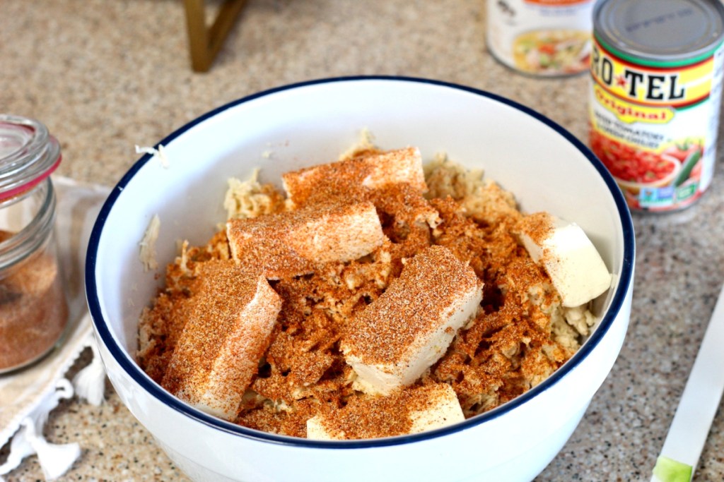 mixing cream cheese and taco seasoning into shredded chicken