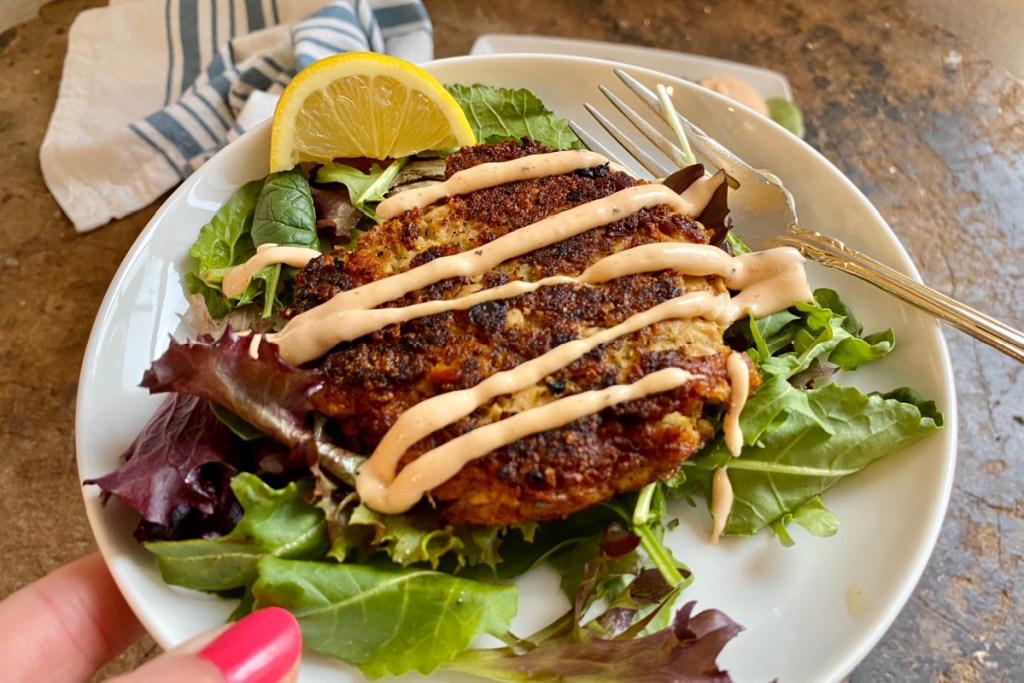 girl holding a plate of salmon patties