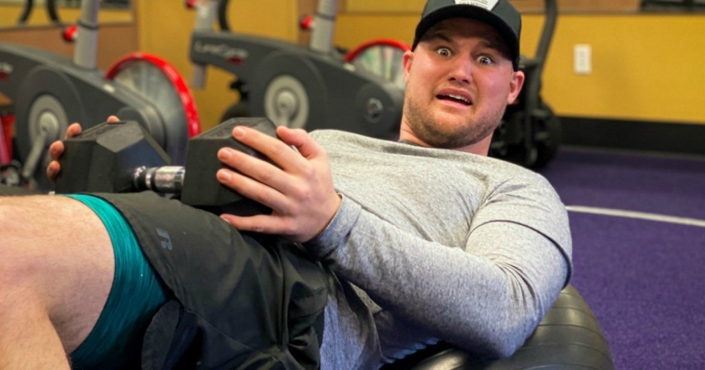 man on his back with dumbbell on lap