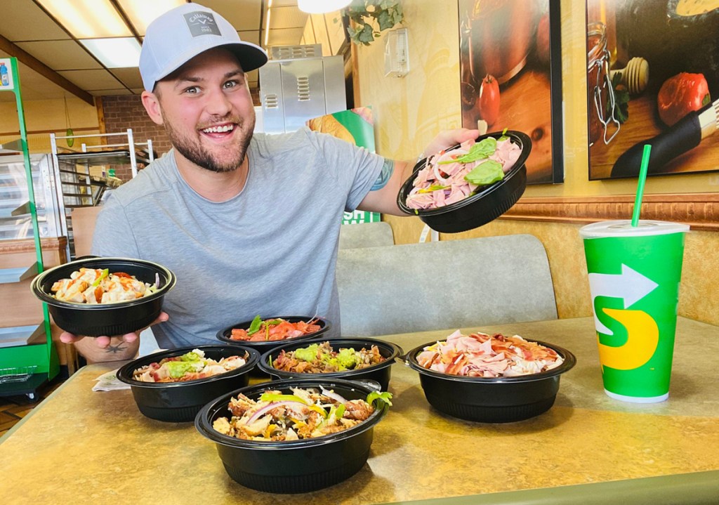 man holding subway protein bowls