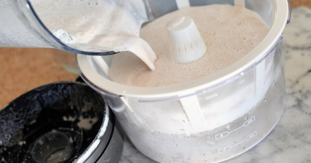pouring blended almond milk into strainer
