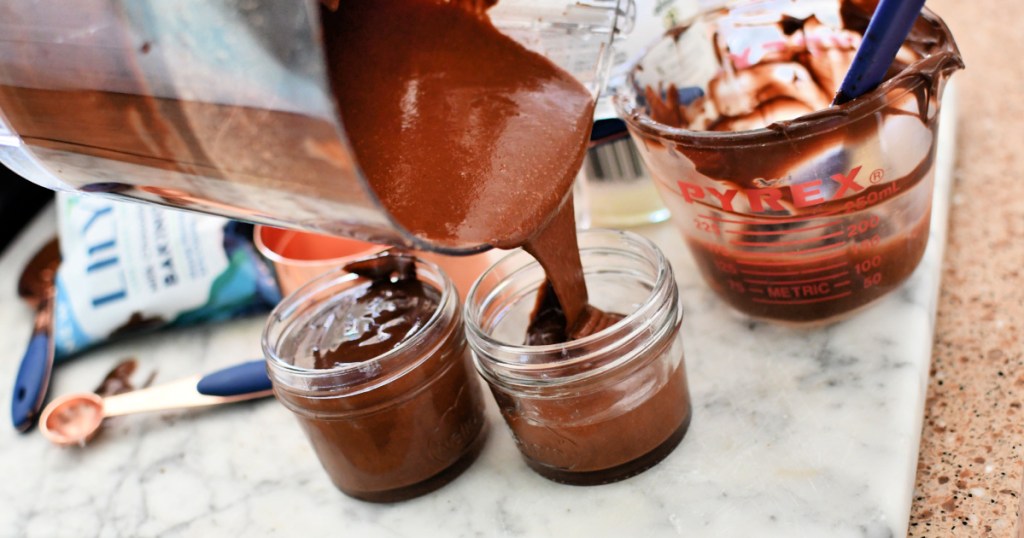 pouring homemade keto nutella into jars 