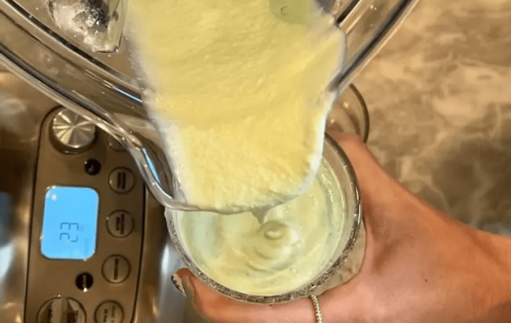 pouring keto shamrock shake into glass 