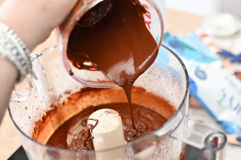 pouring melted chocolate into food processor