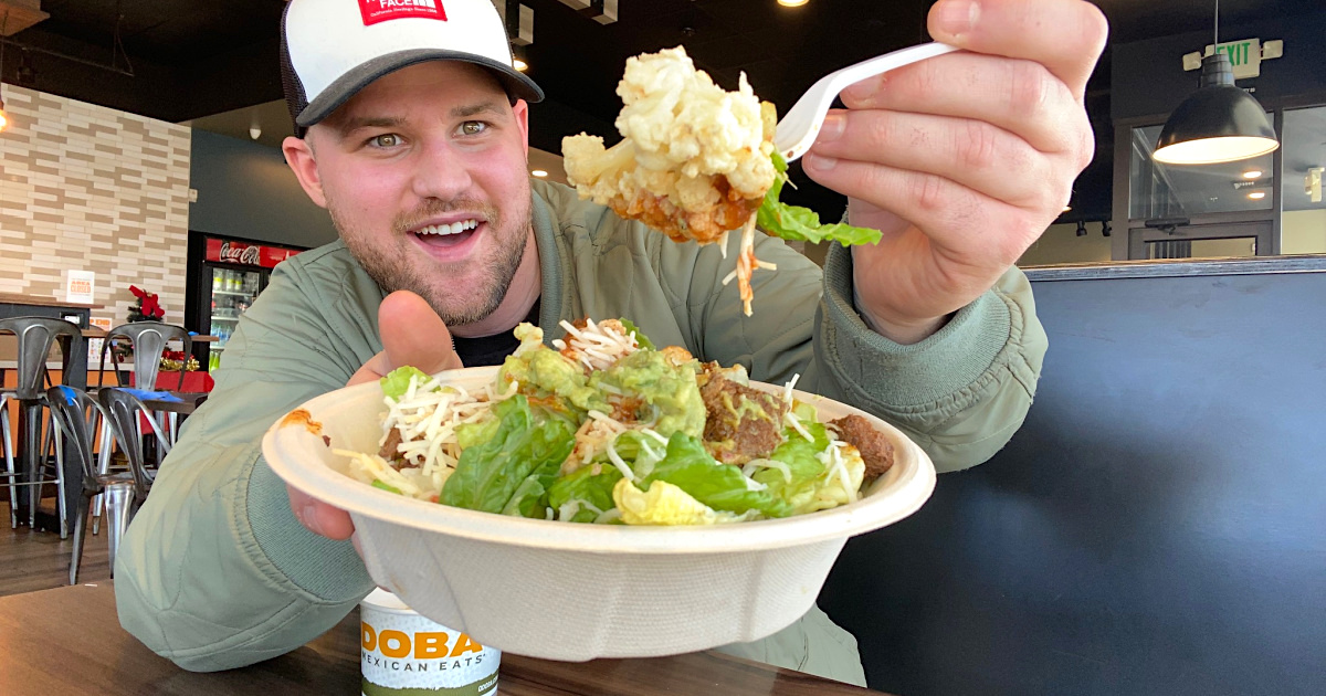 man holding Qdoba salad with cauliflower mash