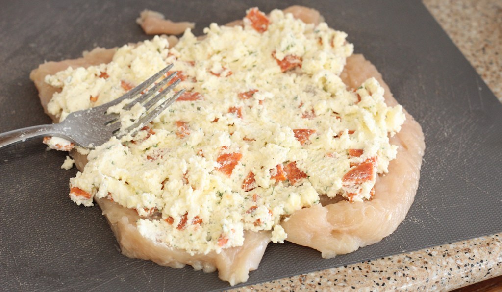 spreading ricotta mixture on pounded chicken for keto lasagna stuffed chicken