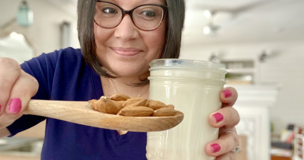 woman holding a jar of almond milk 