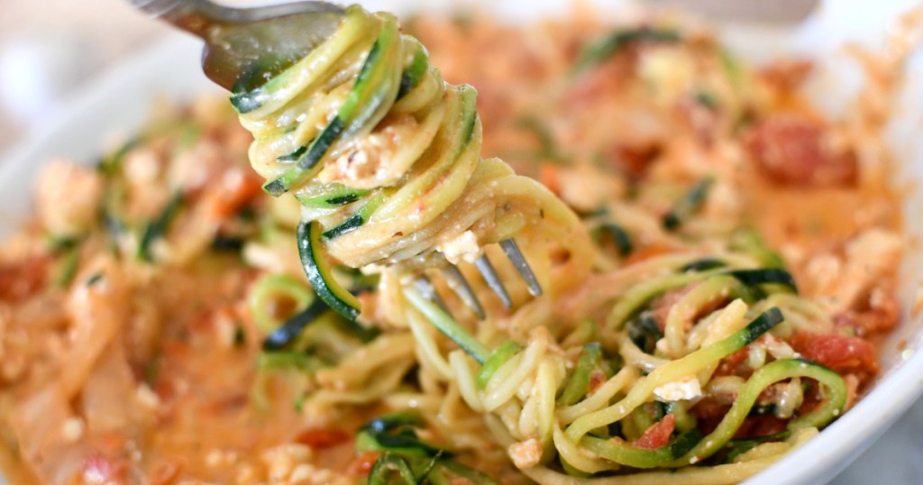 twirling zoodles on a fork with feta 