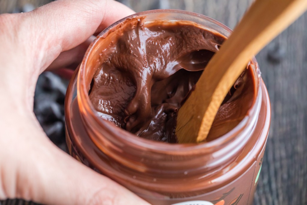 holding jar of choczero keto Nutella dark chocolate hazelnut spread